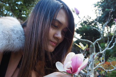 Close-up of beautiful woman smelling flower