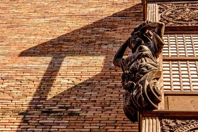 Close-up of statue against brick wall