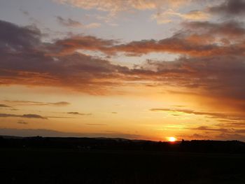 Scenic view of silhouette field against sky during sunset