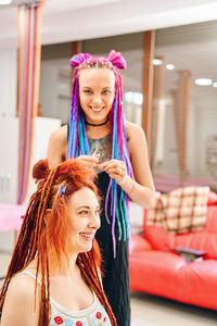 Girl tying hair of her friend