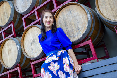 Portrait of young woman sitting on wood