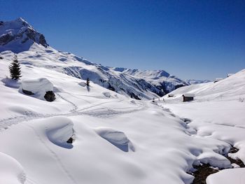 Scenic view of snowcapped mountains against clear blue sky