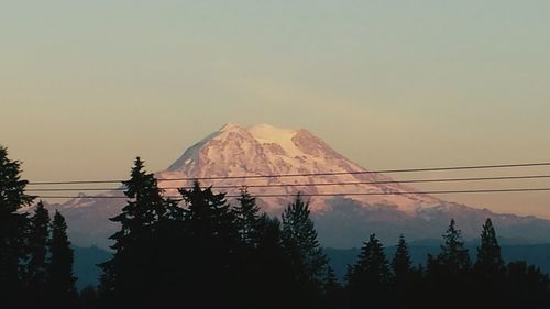 Silhouette trees and mountains against sky during sunset