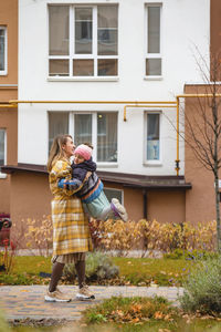 Woman with umbrella against building