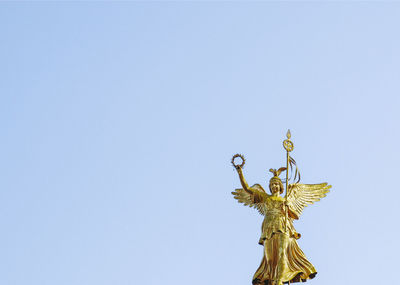 Low angle view of angel statue against clear sky