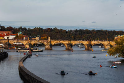 Bridge over river in city against sky