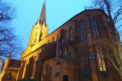 Low angle view of building and trees against sky