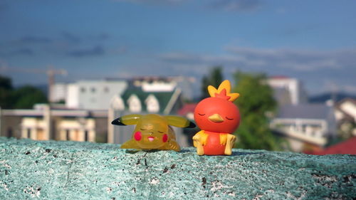 Close-up of toy toys on retaining wall