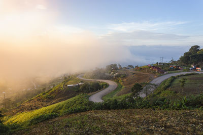 Scenic view of road by mountains against sky