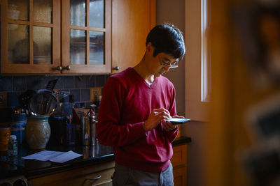 Young woman using mobile phone at home