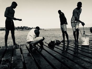 People playing on beach against sky