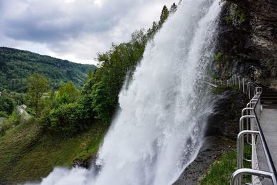 Scenic view of waterfall against sky