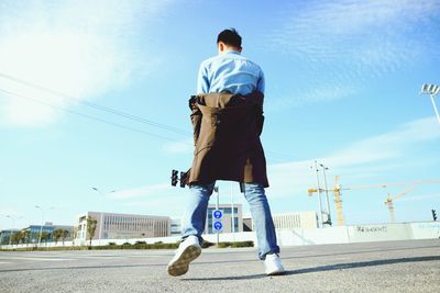 Rear view of man on road against sky
