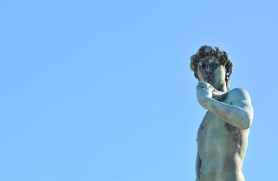 Low angle view of statue against blue sky