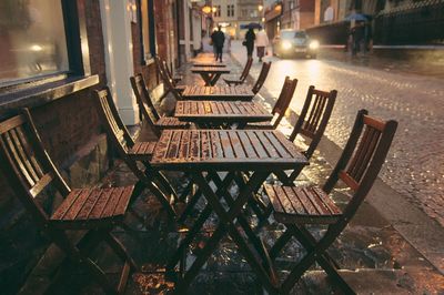 Empty chairs and tables in sidewalk cafe