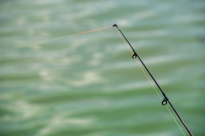 Close-up of fishing rod over lake