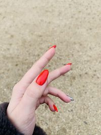 Close-up of hand holding red leaf