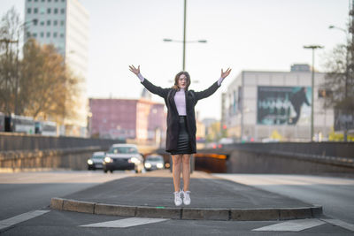 Full length of woman in mid air on city street