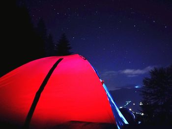 Low angle view of illuminated tent against sky at night