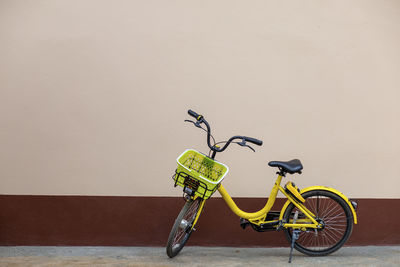 A yellow bicycle parked next to the house leave space for the text.