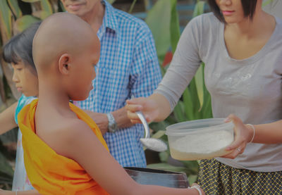 Midsection of woman holding ice cream standing outdoors