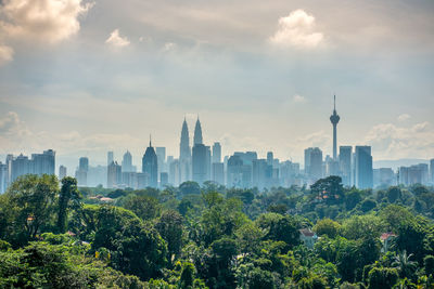 View of cityscape against cloudy sky