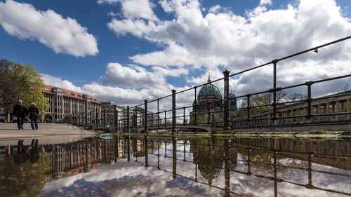 Reflection of berlin cathedral on puddle against sky