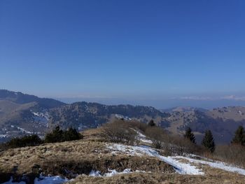 Scenic view of snowcapped mountains against clear blue sky