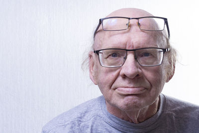 Portrait of man wearing eyeglasses against wall