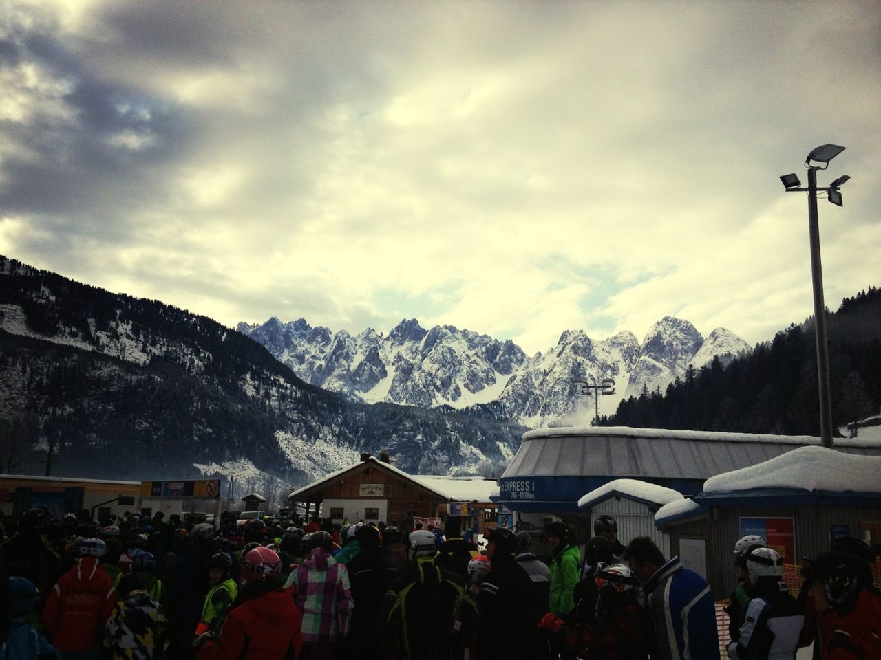 mountain, sky, lifestyles, mountain range, snow, large group of people, men, winter, cold temperature, leisure activity, person, cloud - sky, weather, building exterior, tourist, season, snowcapped mountain, built structure, cloud