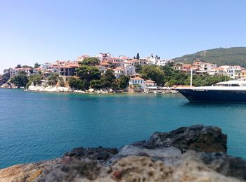 Scenic view of town by sea against clear sky