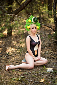 Portrait of young woman sitting on tree