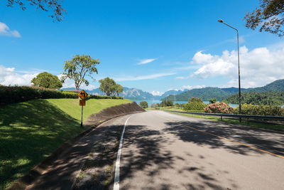 Road amidst trees against sky