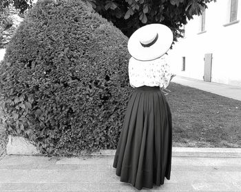 Rear view of woman standing by tree