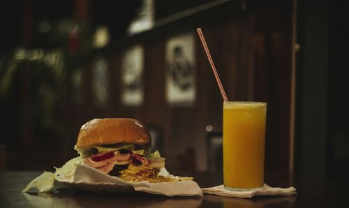 Close-up of burger and juice on table