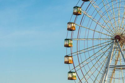 Low angle view of ferris wheel against clear blue sky