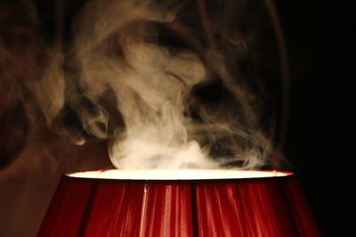 Close-up of smoke over illuminated lamp