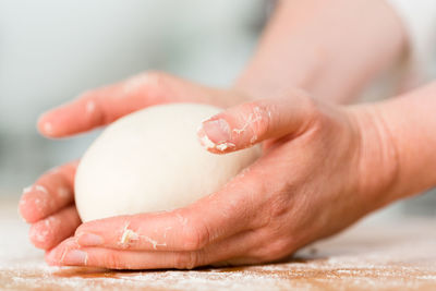 Close-up of hands kneading dough