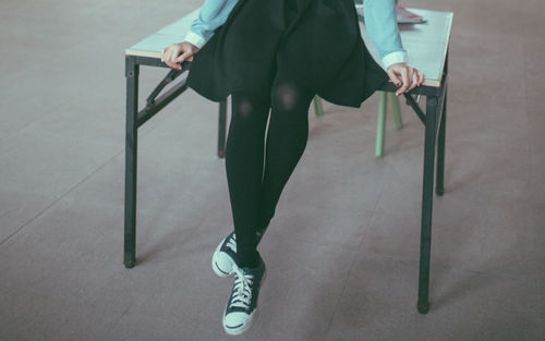 Low section of woman sitting on chair