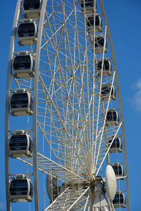 Low angle view of ferris wheel against blue sky