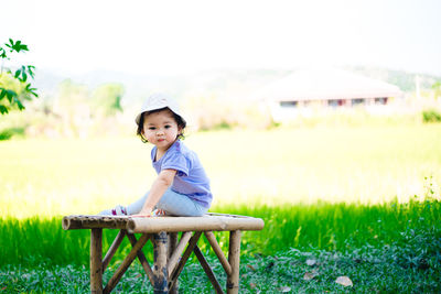Portrait of cute baby girl on field