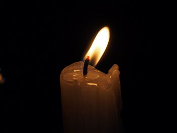 Close-up of burning candle in darkroom