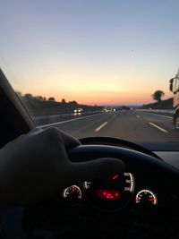 View of car on side-view mirror at sunset