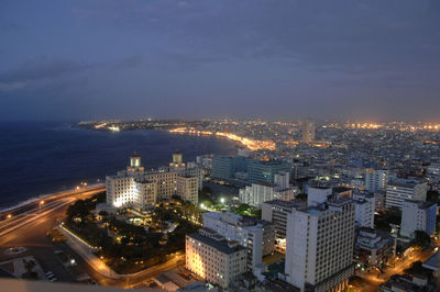 High angle view of illuminated cityscape against sky at night