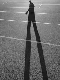 Shadow of man walking on running track