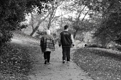 Rear view of people walking on footpath