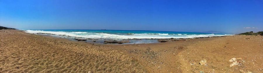 Scenic view of beach against clear blue sky