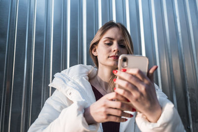A pretty girl looks into a smartphone and takes a selfie. high quality photo