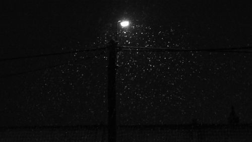Close-up of illuminated metal against sky at night