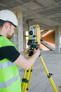 Surveyor engineer working at construction site with measuring equipment (total station)